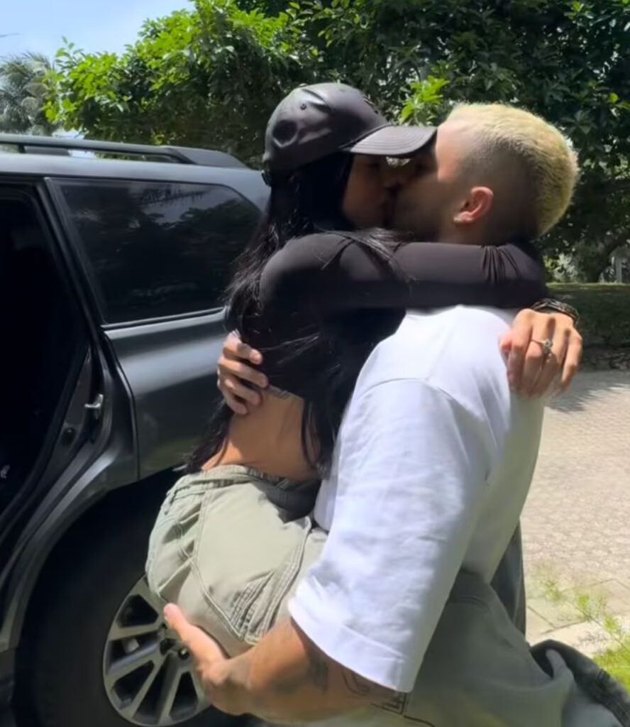 La influencer Karina García con su novio, el reguetonero Altafulla. Al fondo una camioneta de alta gama. Foto / Redes Sociales
