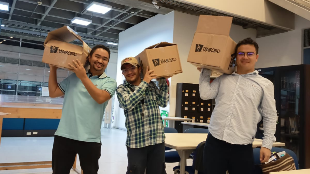 Tres hombres con cajas en sus hombros.