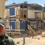 Casa azul de dos pisos, de bahareque, destruida por el terremoto.