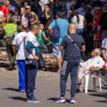 Ancianos en la calle y al fondo escombros de terremoto