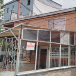 Aviso de "se arrienda", al lado de un edificio averiado por el terremoto
