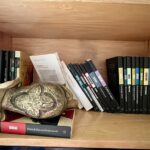 Foto de la biblioteca de Mariana Aranda, autora del texto que acompaña esta imagen. Libros caídos y un adorno de un elefante dorado también caído.