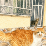 2 gatos en la puerta de una casa