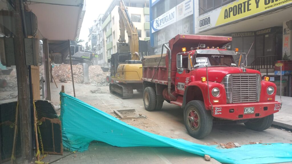 Volqueta y retroexcavadora recogiendo escombros