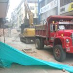 Volqueta y retroexcavadora recogiendo escombros