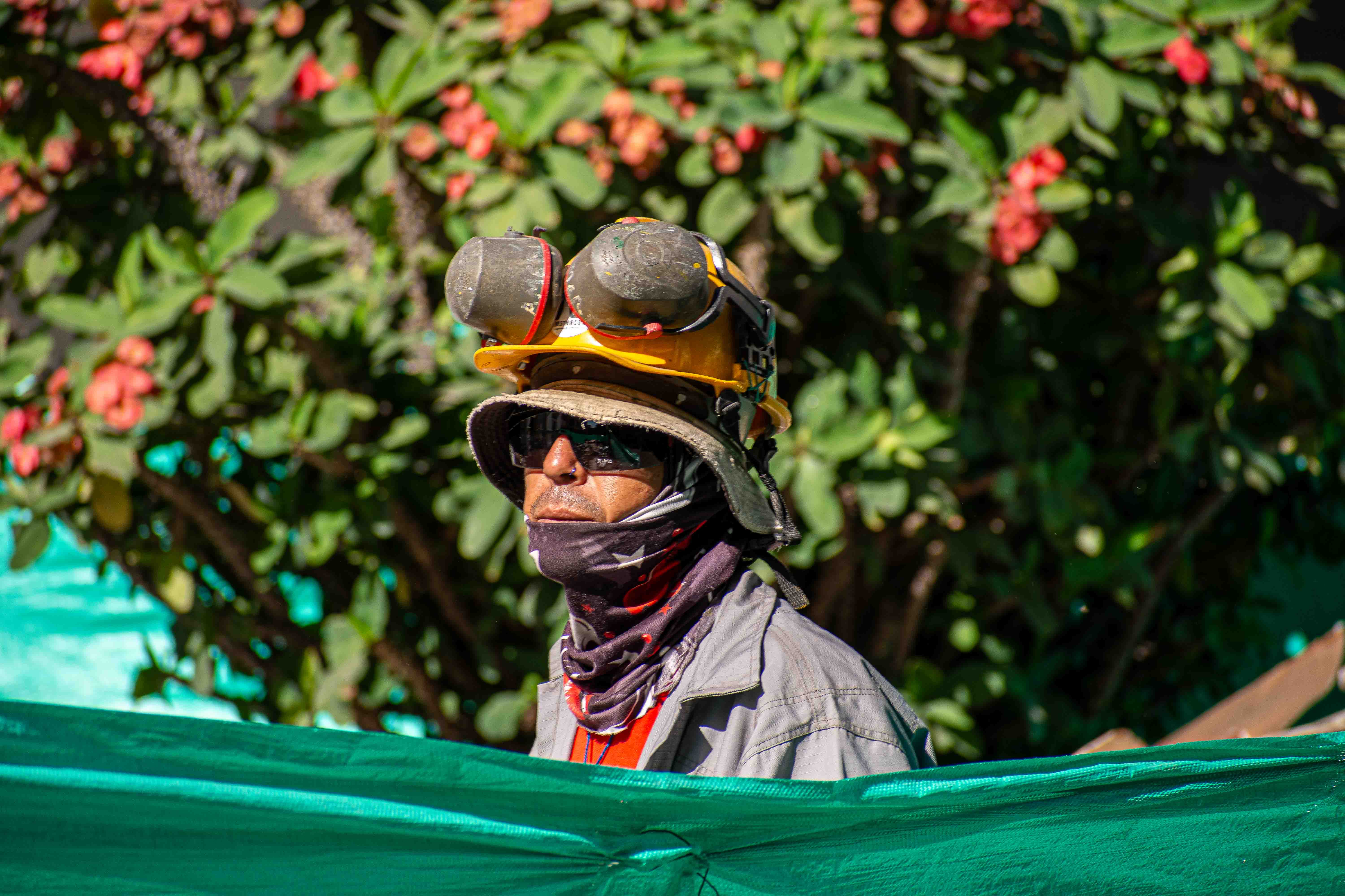 Obrero con gafas, casco y protección en los oídos.