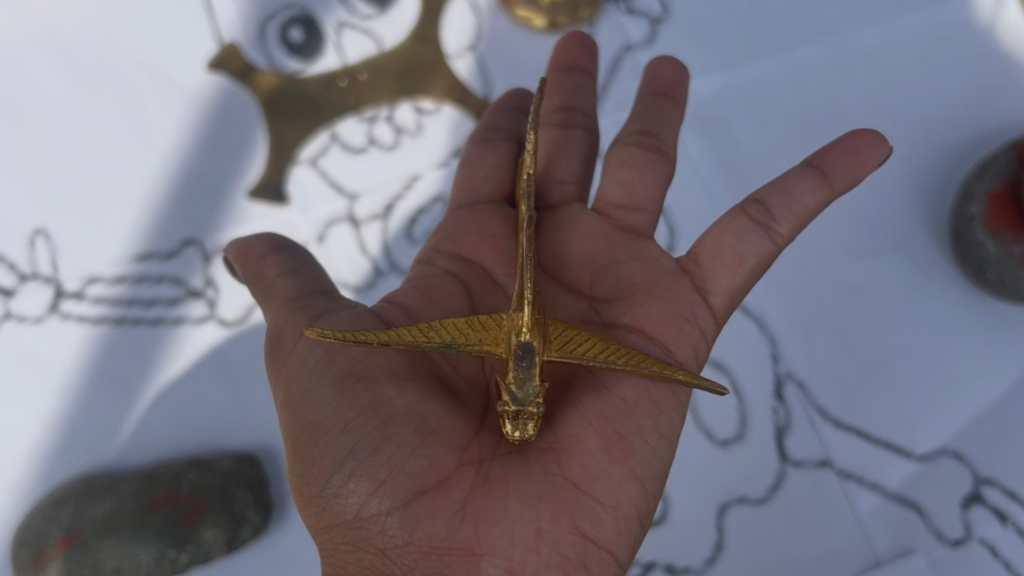 Una foto de una mano extendida que sostiene un pez dorado.