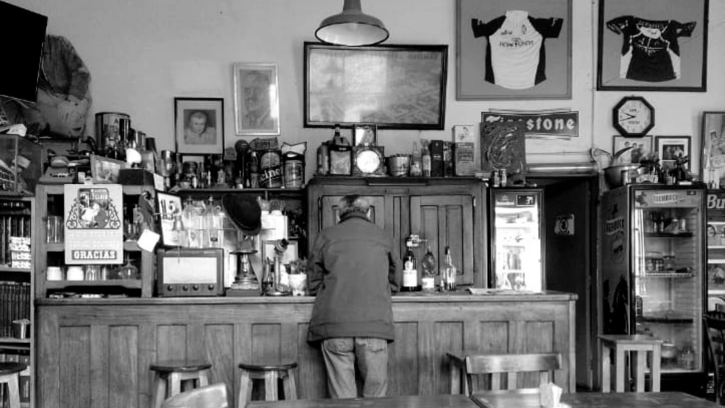 Foto del Bar Las Heras en el que se ven mesas, el mostrador, y una persona dando la espalda. Asumimos que es uno de los personajes mencionados en el texto.