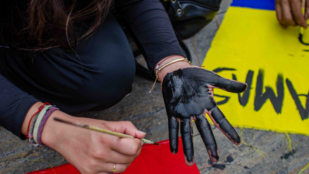 Foto de una persona que se pinta una mano de color negro durante las marchas en Manizales.