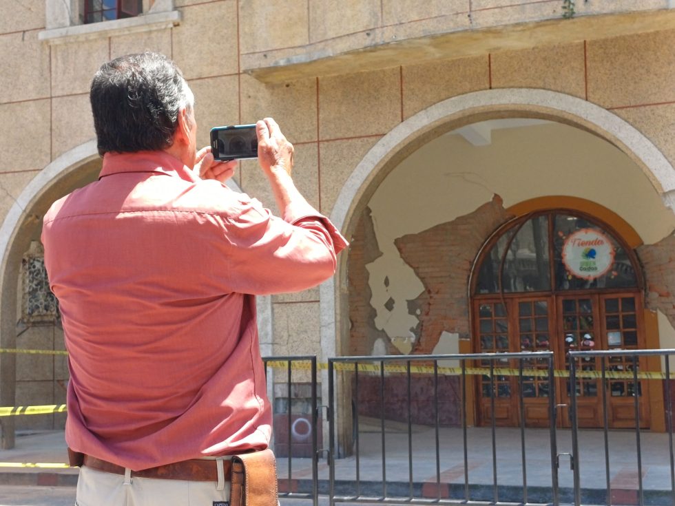 Imagen de un señor tomándole una foto al edificio de la Licorera en el Centro de Manizales donde hoy funciona una sede de la Gobernación de Caldas.