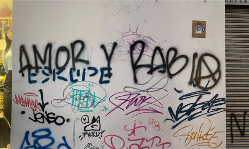 Pared pintada con muchos grafitis entre los que sobresale uno que dice amor y rabia.