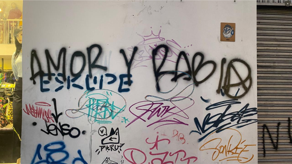 Pared pintada con muchos grafitis entre los que sobresale uno que dice amor y rabia.