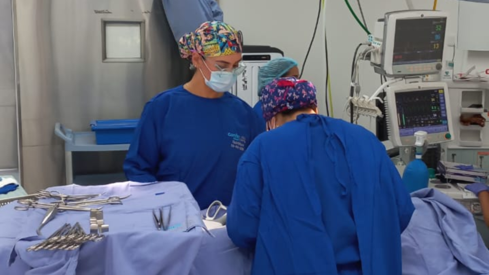 Dos médicos de bata azul en una cirugía