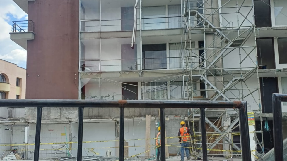 Edificio averiado por terremoto. Andamios y gente reparándolo