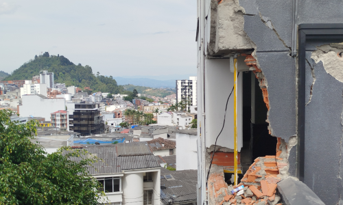 Edificio con daños por terremoto y al fondo el Morro San Cancio