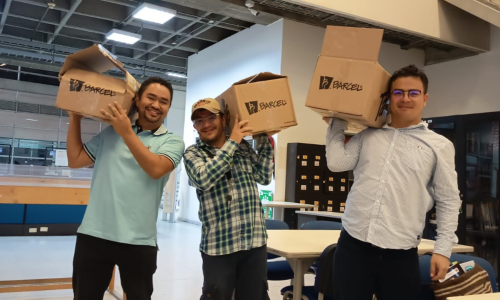 Tres hombres con cajas en sus hombros.