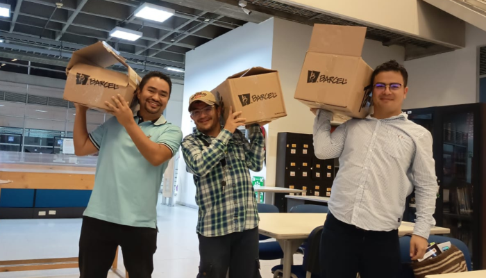 Tres hombres con cajas en sus hombros.