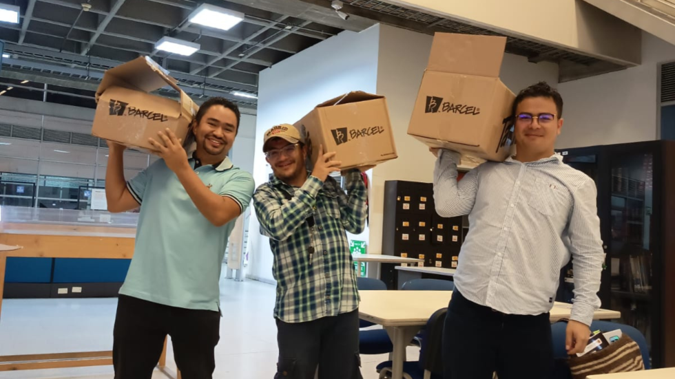 Tres hombres con cajas en sus hombros.