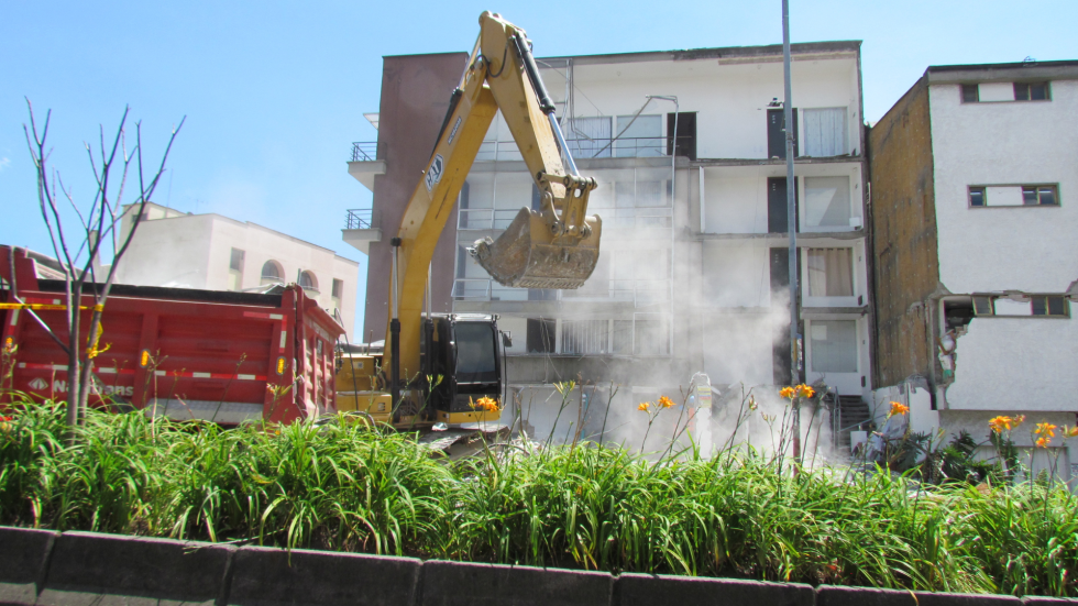 Retroexcavadora recogiendo escombros