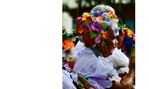 Detalle de una foto en la que se aprecia una mujer mayor con flores en la cabeza