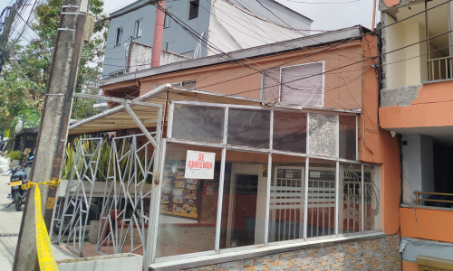 Aviso de "se arrienda", al lado de un edificio averiado por el terremoto