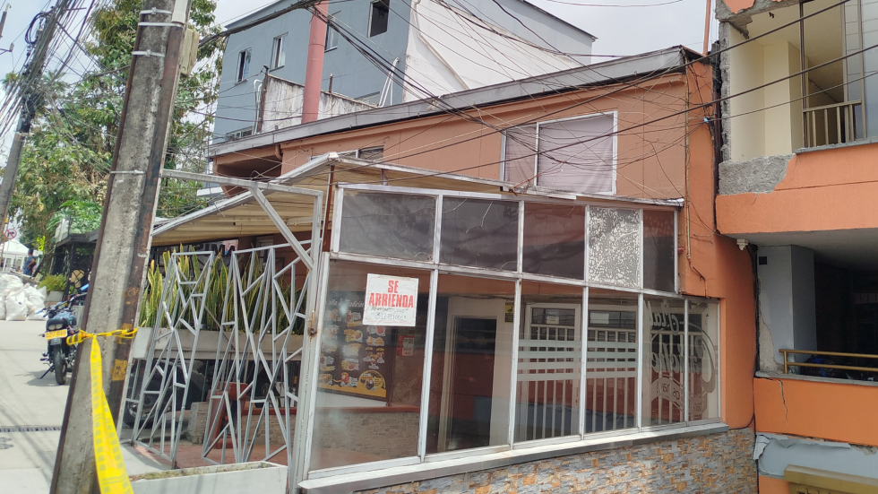Aviso de "se arrienda", al lado de un edificio averiado por el terremoto