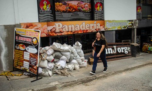 Mujer caminando en una calle con escombros