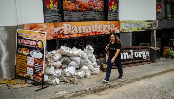 Mujer caminando en una calle con escombros
