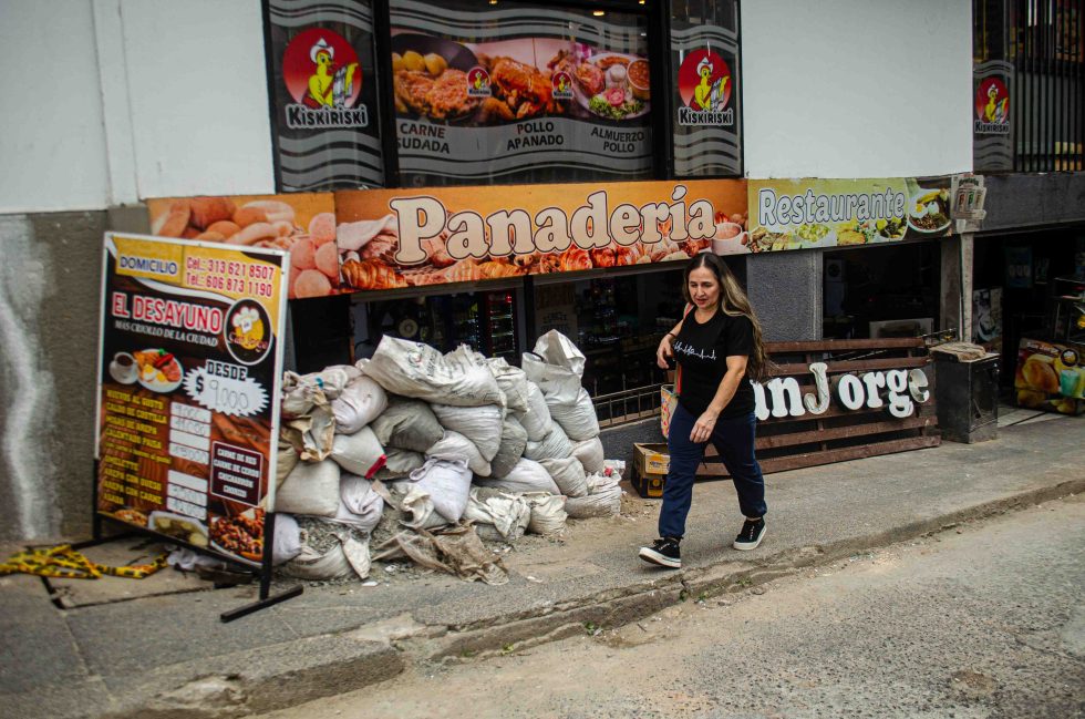 Mujer caminando en una calle con escombros