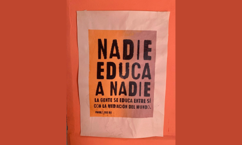 Afiche pegado en una pared que dice Nadie Educa a Nadie,