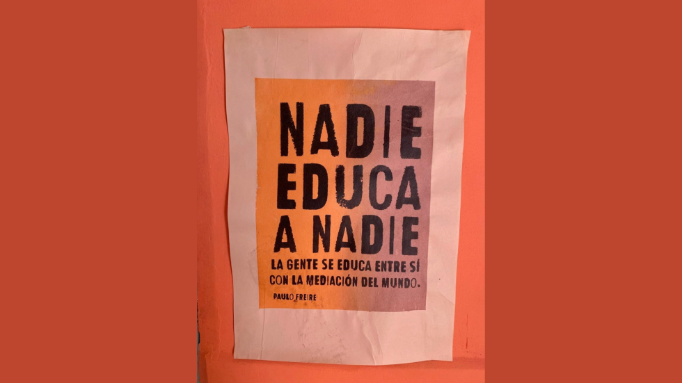 Afiche pegado en una pared que dice Nadie Educa a Nadie,