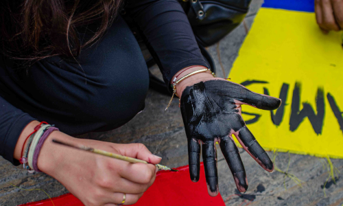 Foto de una persona que se pinta una mano de color negro durante las marchas en Manizales.