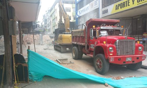 Volqueta y retroexcavadora recogiendo escombros