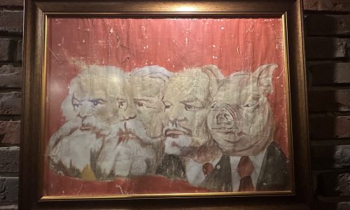 El cerdo es la evolución de Marx, Engels y Lenin, según este cuadro que reposa en el restaurante El Cerdo rojo, en Varsovia (Polonia). /