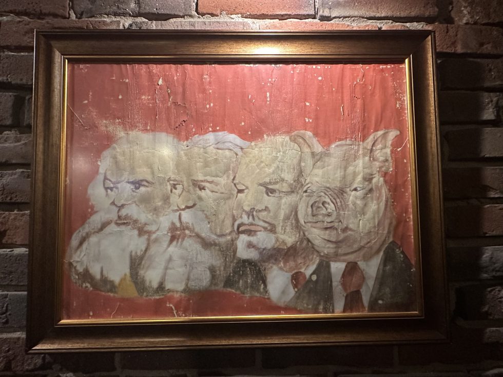El cerdo es la evolución de Marx, Engels y Lenin, según este cuadro que reposa en el restaurante El Cerdo rojo, en Varsovia (Polonia). /