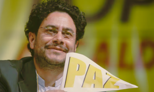 Foto del rostro de Iván Cepeda, sonriente y con un banderín de la paz
