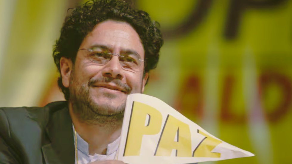 Foto del rostro de Iván Cepeda, sonriente y con un banderín de la paz