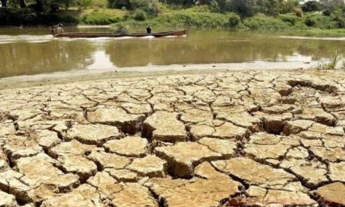 Imagen de tierra seca y al fondo un río mermado en su cauce