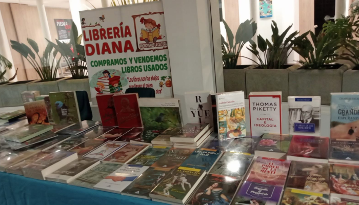 Foto del interior de la librería Diana, con una mesa llena de libros.