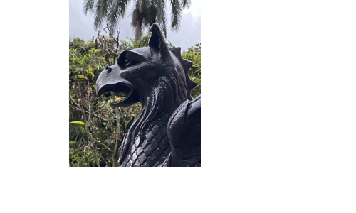 Fragmento de la cabeza de una escultura pública de color negro. Es un ave monstruosa