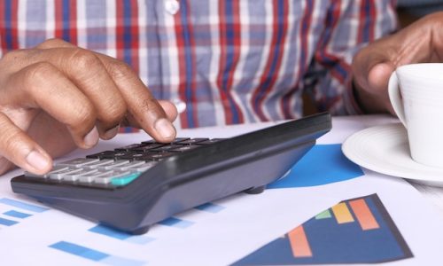 persona-mano-usando-calculadora-escritorio_260672-235-2860656152